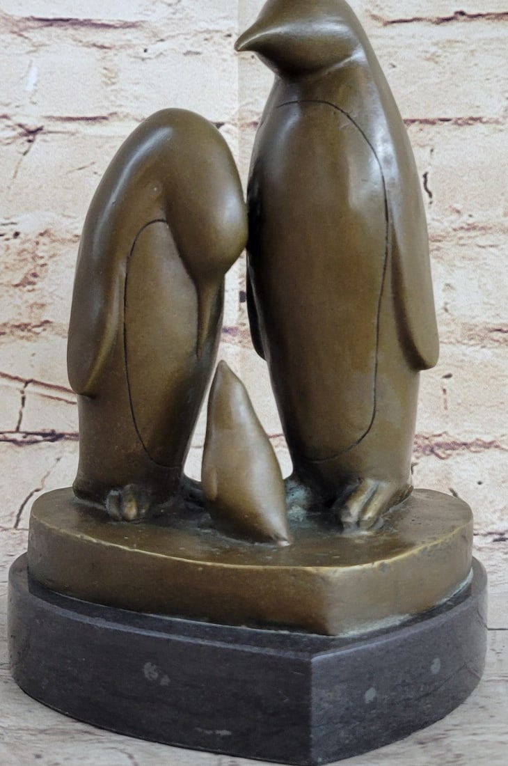 Penguin Trio Bronze Sculpture: The penguin pair stands among the arctic gales protecting and nurturing their newborn. The trio stands upon a heart-shaped bronze plinth. In animal symbolism, the penguin is a symbol of agility, drive