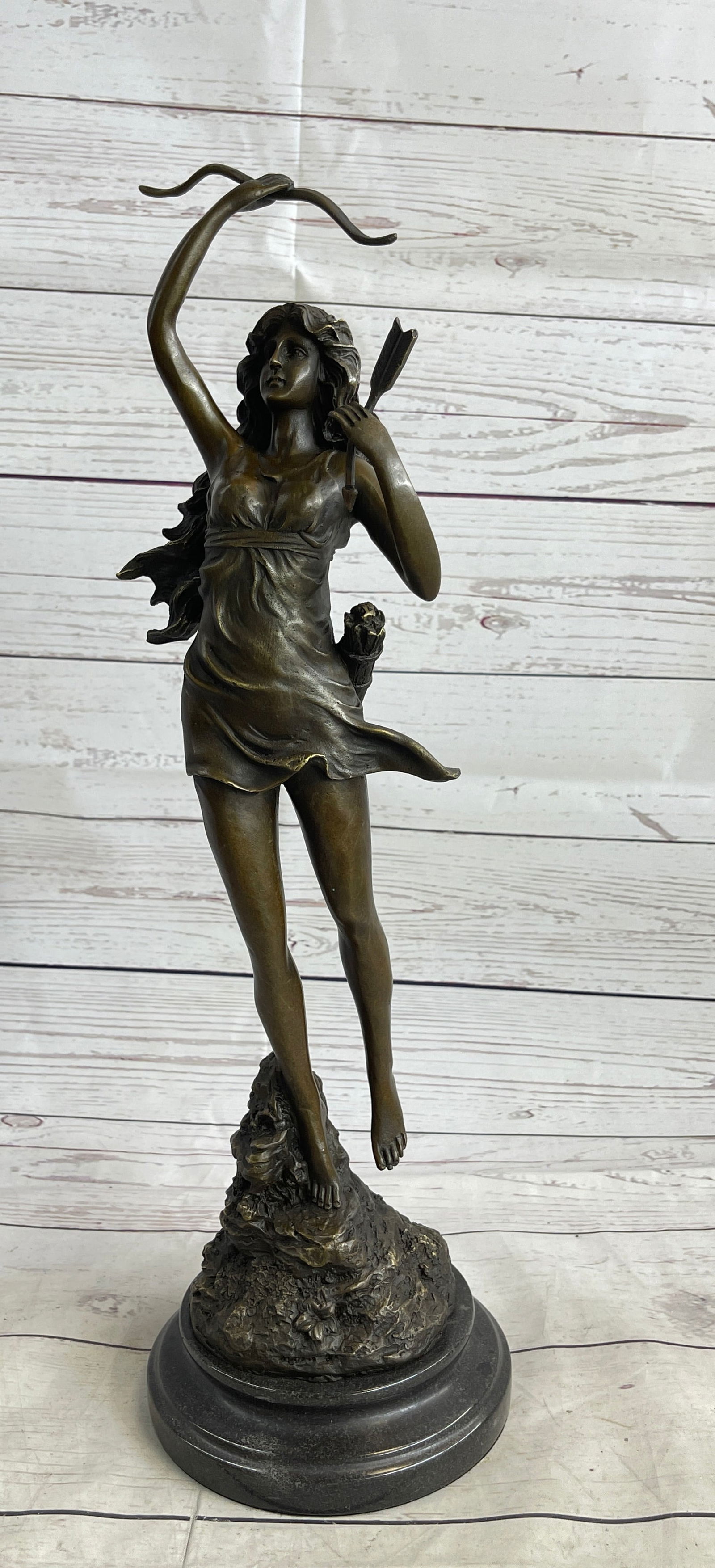 Diane The Hunter Bronze Sculpture: This curvaceous beauty runs away with his bow and sack of arrows. She holds an arrow in one hand and holds up the coveted bow in the other. This brown patina sculpture was cast using the Lost Wax Meth