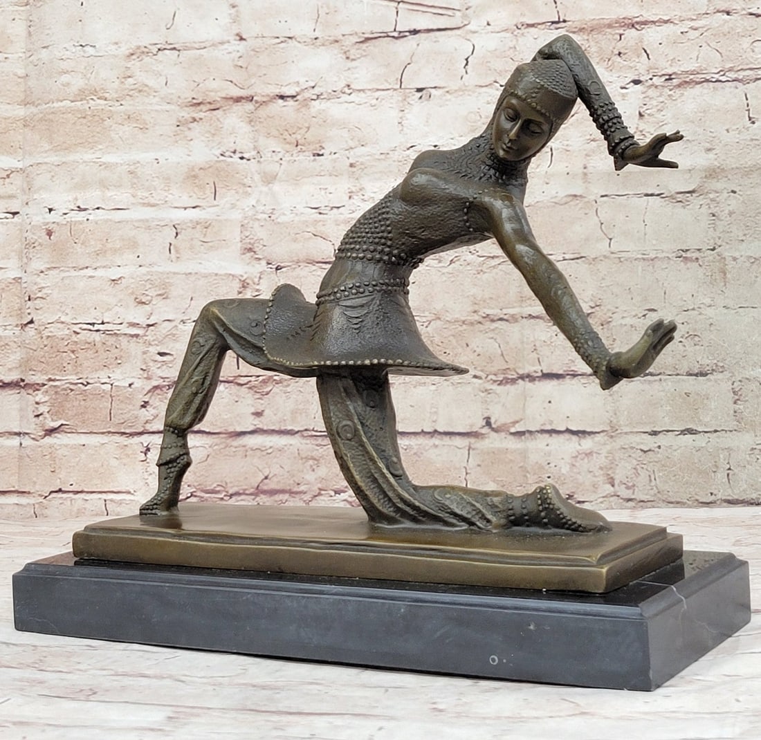 Dancer Bronze Statue: A graceful dancer puts on a show. She has a dancer long lean body and elegant moves. Her head tilts to the side as one of her arms reaches over her head and behind and the other one is just straight o