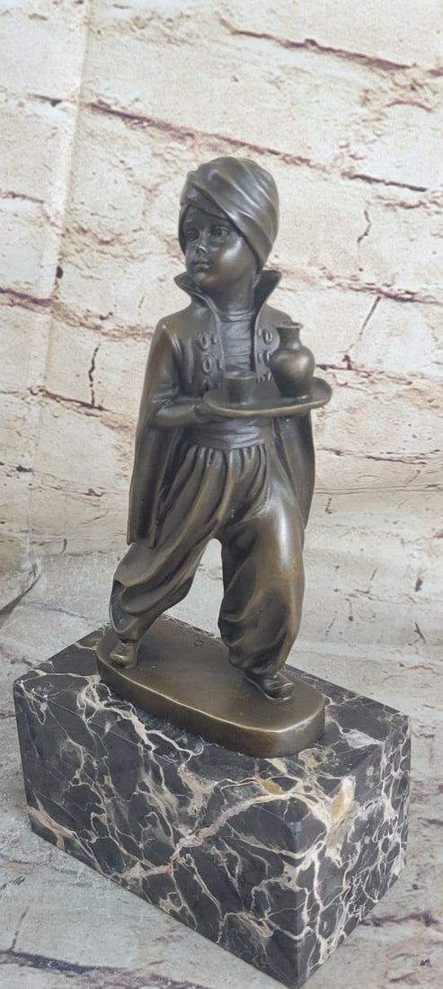 Little Indian Boy Alibaba The Server Bronze Sculpture: A young Arabian boy is a servant in a grand palace. He carries a small waiter with a round bottle for his master to quench his thirst. His hair is wrapped up in a turban and he wears a loose jumpsuit.