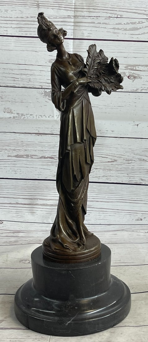 Feather Gown Bronze Sculpture: This unique Sculpture of a 1920s woman with four feathers in her right hand standing proudly for the silent era. Her unforgettable dress drops all the way to the floor from the back, while the front s