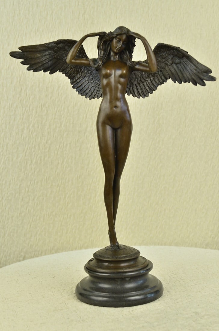 Lady Angel Bronze Statue: Descending Night About the Sculpture. It depicts a nude female angel with her head downcast, her arms softly brushing her hair, which cascades glowingly down her back. Her extended large wings are cra
