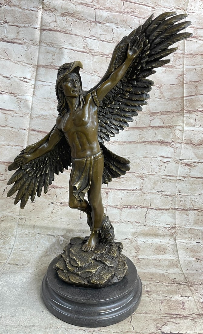 Winged Native American Indian Eagle Bird Bronze Statue: Celebrate the Native American culture with a Native American statue inspired by Indian tribes of the past with this piece that depicts a Native American man wearing eagle fur on his back. He raises hi