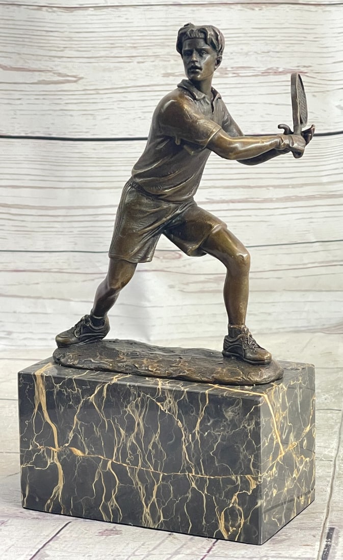 Tennis Player Bronze Sculpture: He eyes the swing of his opponent and waits for the green ball to soar back over the net. He lunges to the side and prepares to swing his racket. This pro tennis player is dressed in a loose cotton sh