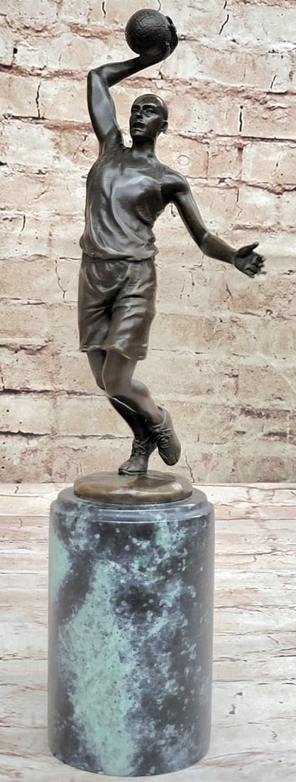 Basketball Bronze Figure: He is a legend on the court. This basketball player tumbles down the court. As he nears the three-point line, he holds the ball in his large palm and prepares to shoot. He begins to leap towards the n
