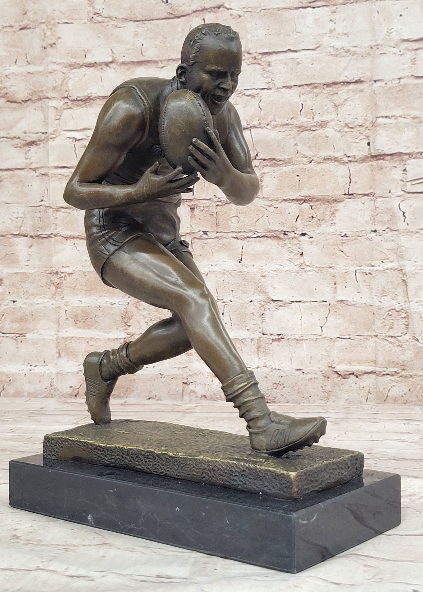 Rugby Player Bronze Sculpture: A muscular Rugby player runs for the end field, trying to skip the yards and avoid being tackled. His powerful legs ache as he sprints and dodges. He Kicking the ball under his protectively. Every onc