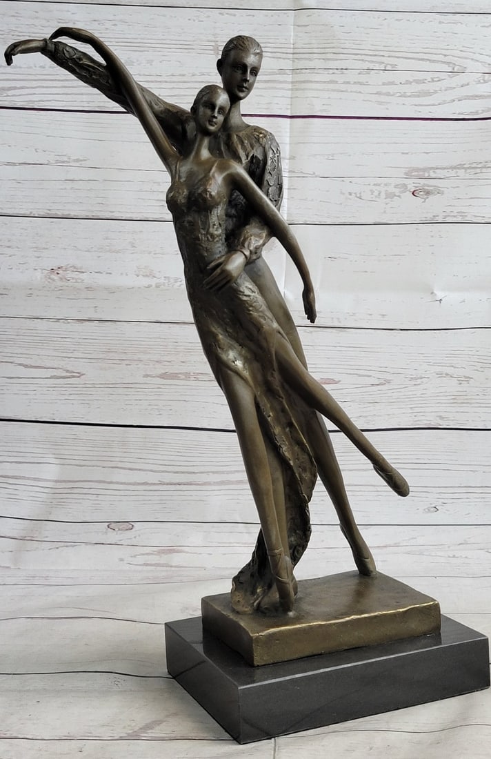 Ballerina Dancers Bronze Sculpture: The Bronze ballerina stands balancing all of her gentle weight on her partners, while he supports her on his right leg. She daintily masters her attitude en point dance pose as her left leg curves bac