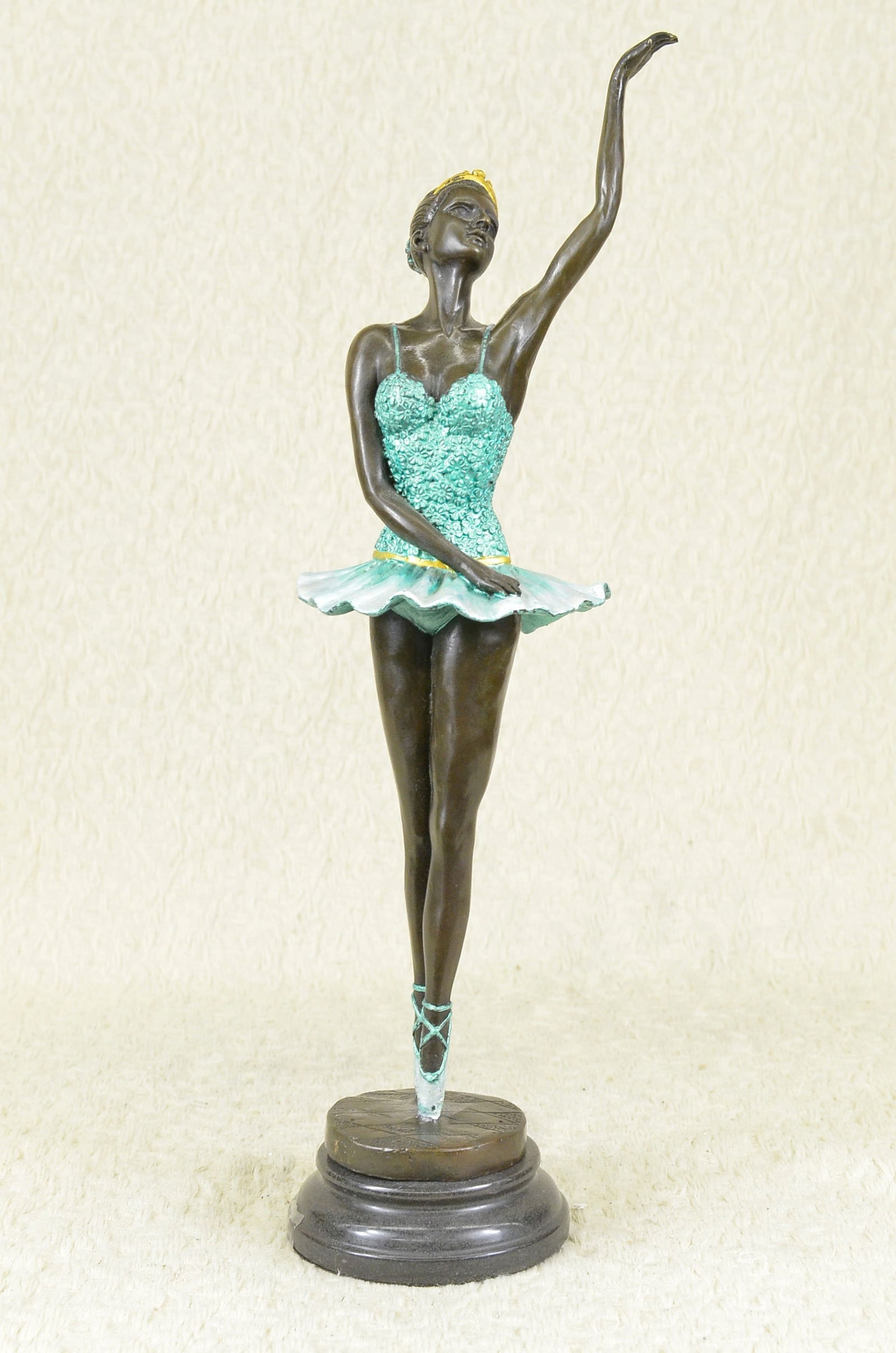 Well Trained Ballerina Bronze Statue: The ballerina stands tall and elegant as she looks to the heights of the balcony lovingly waving to the admiring audience in a standing ovation. She wears a tiara and a tutu, the classic costume of th