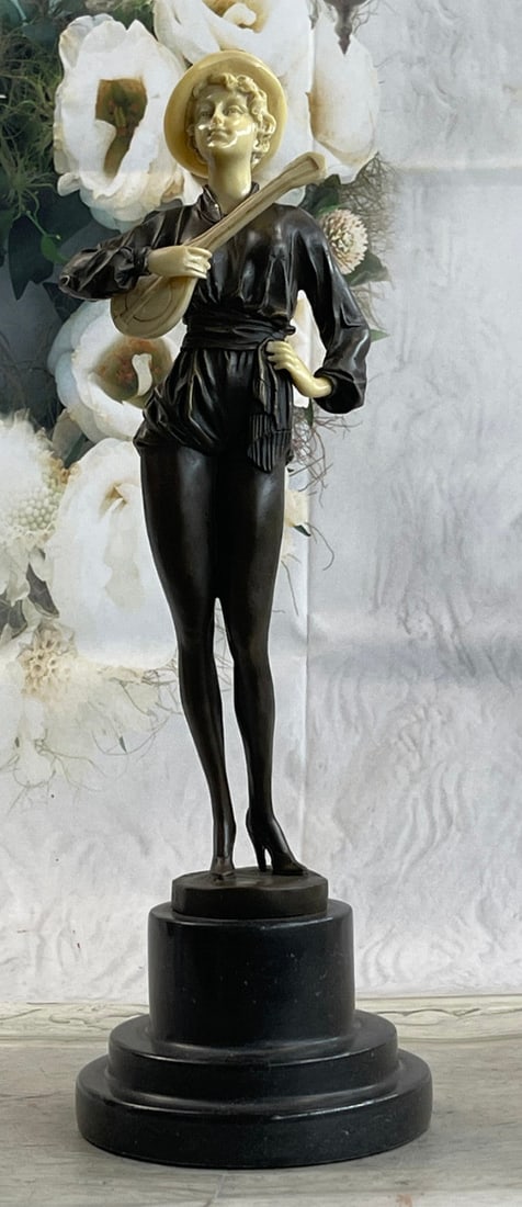 Beautiful Guitar Player Bronze Sculpture: This beautiful woman rests the little guitar on her chest while she holds it with one arm. The other hand is placed on her waist as she poses for the picture. She has this gorgeous one-piece shorts su