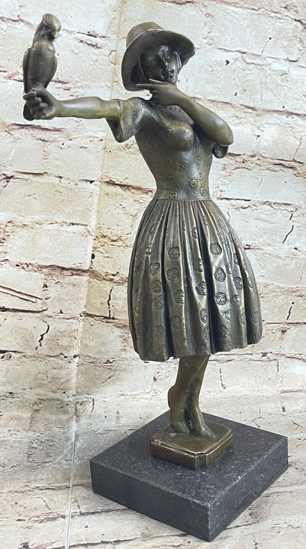 Woman Dressed Feminine Sundress holding Parrot Bronze Sculpture: The delightful young woman is dressed in a classy and feminine sundress. Her chic sunhat rests on her head with her bob peeking through the bottom. Adding to the beauty of the sculpture a pleasant bir