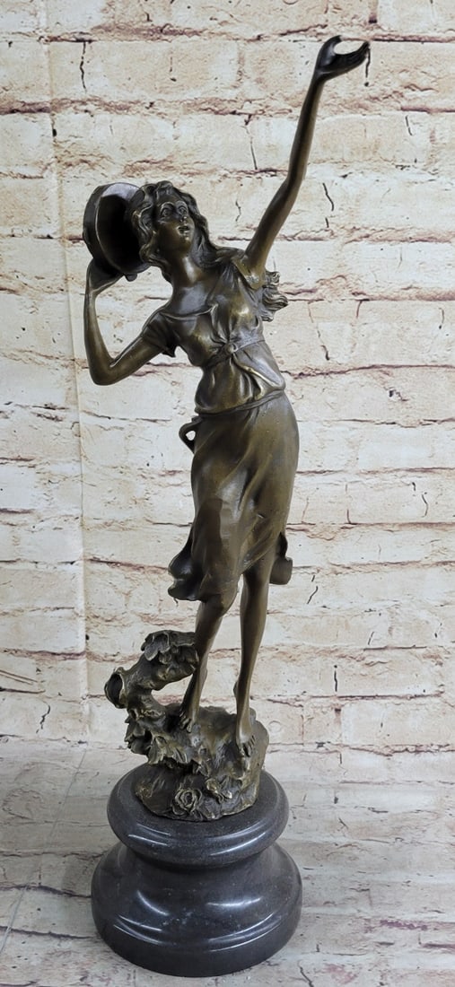Dancer Bronze Sculpture: Calling to the winds above the young woman looks to the sky and taps her tambourine to her head. Her long hair and dress flow from the soft breeze of the wind. She stands barefoot out on the land amid