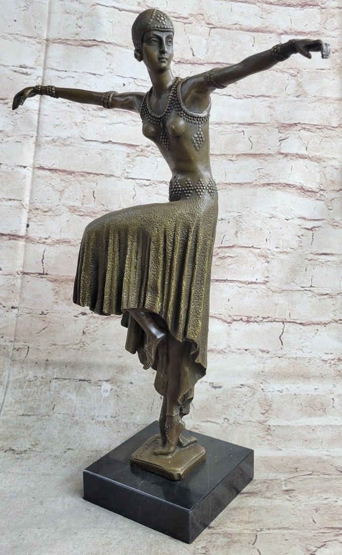Turkish Dancer Bronze on Marble Base Sculpture: The lithe dancer balances on one leg in a graceful pose. Her other leg bends in a posse, her arms extend in a to the side. Her long skirt raises with her leg. Studs adorn the entire costume. The Sculp