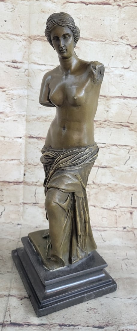 Nude Female Bronze Sculpture: The piece had two arms. The woman stands half-nude with her garments draped over her lower body. Her abdomen is defined, and her chest is bare. Owning this piece will allow you to own a piece of art h