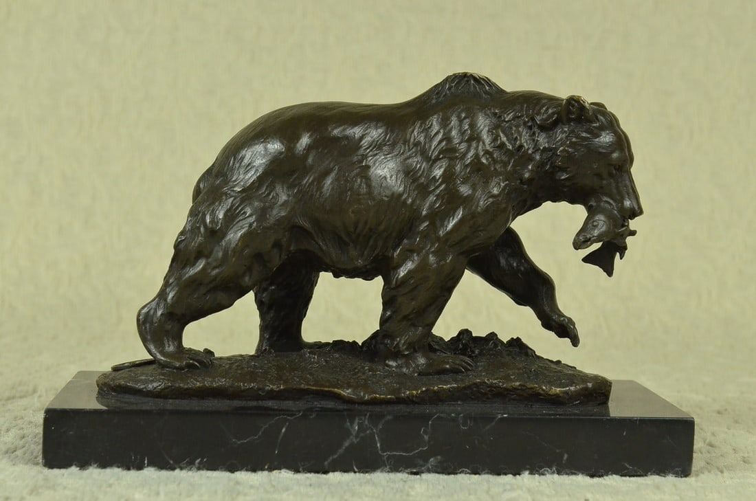 Grizzly Bear Hunting Fish Bronze Sculpture: A young bear standing on top of a cliff leaning its weight into a rock, strong and very big animals such as the bear are incredible to watch. It shows the bear had just caught a fish that wriggles hop