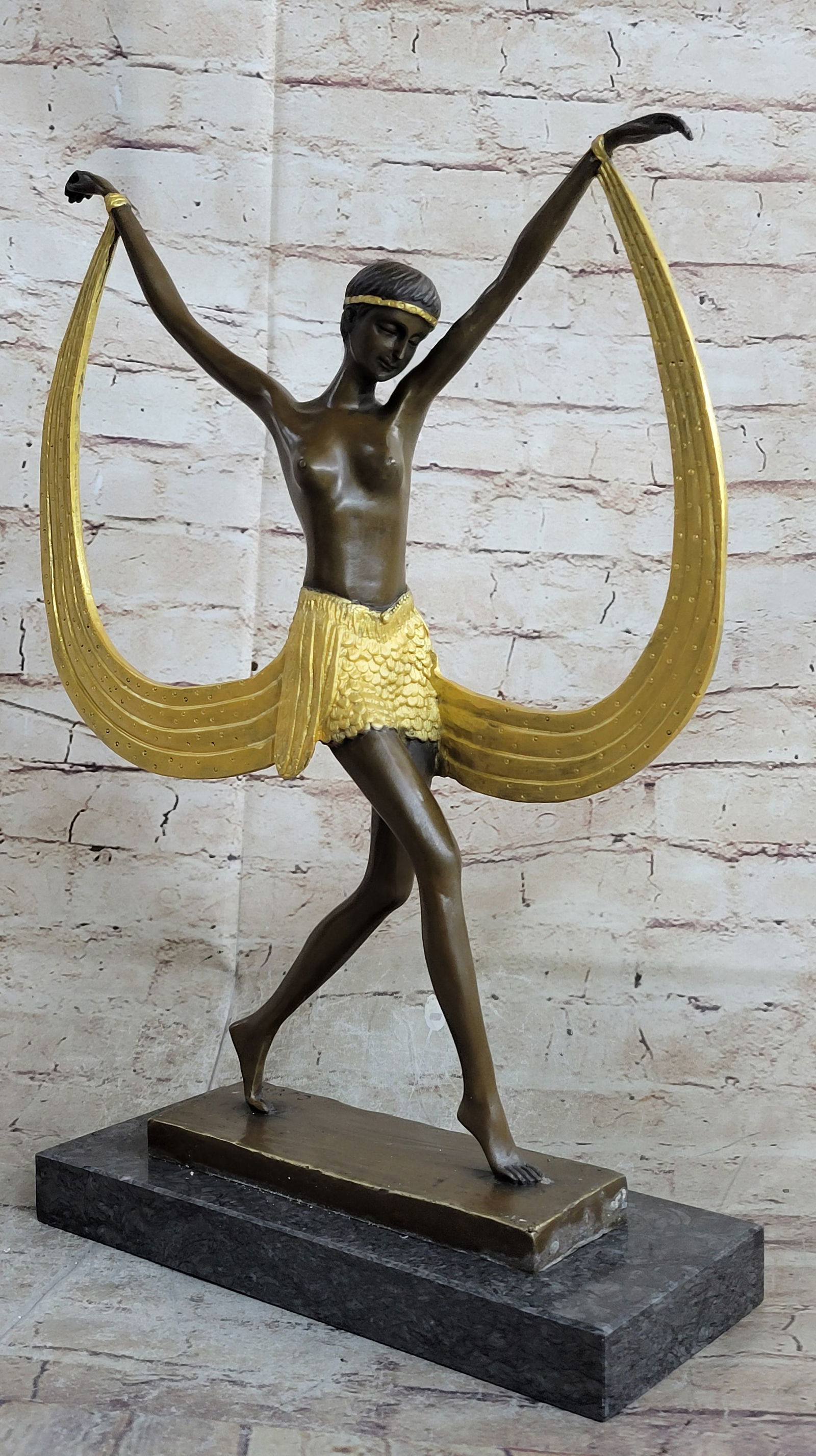 Dancer Bronze Figurine: The belly dancer is light on her feet and fluid with her waistline. She stretches her arms out to her sides as she glides across the floor on the balls of her feet. A long sash is attached to her wris