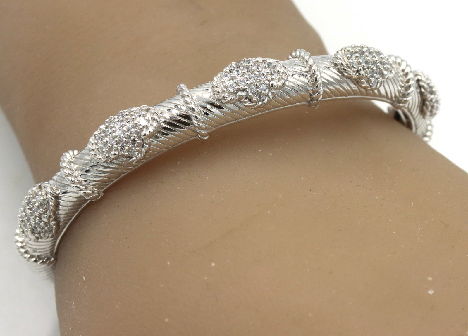 Judith Ripka CZ station hinged cuff bangle: Judith Ripka cubic zirconia station hinged cuff bangle in 925 sterling silver. The total weight of the bangle is 29 grams.