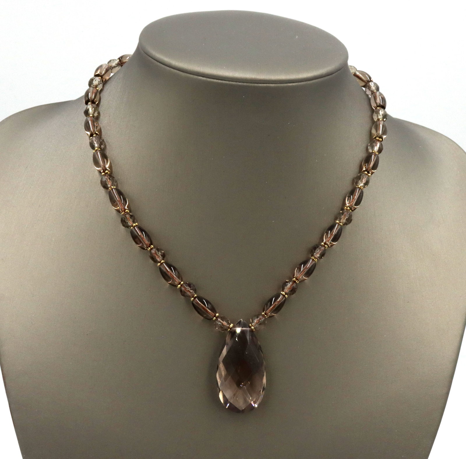 Smokey quartz beaded necklace with tear drop pendant: Smokey quartz beaded 16-inch necklace with tear drop pendant and 14kt yellow gold lobster clasp. The total weight of the necklace is 28.2 grams.