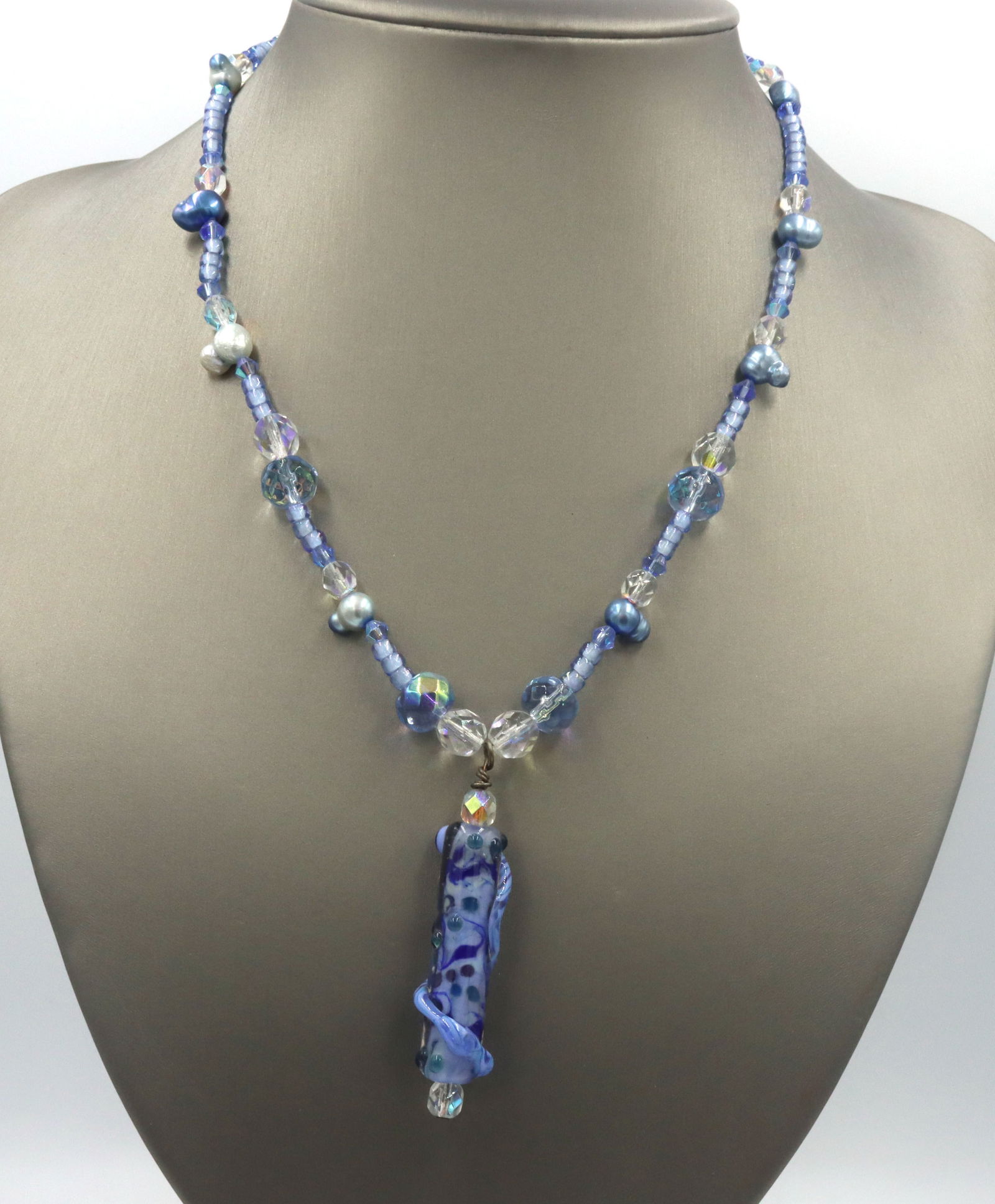 Blue and white crystal rhinestone pendant on beaded necklace: Blue and white crystal rhinestone pendant on 17-inch beaded necklace with 925 sterling silver clasp. The total weight of the necklace is 28.4 grams.