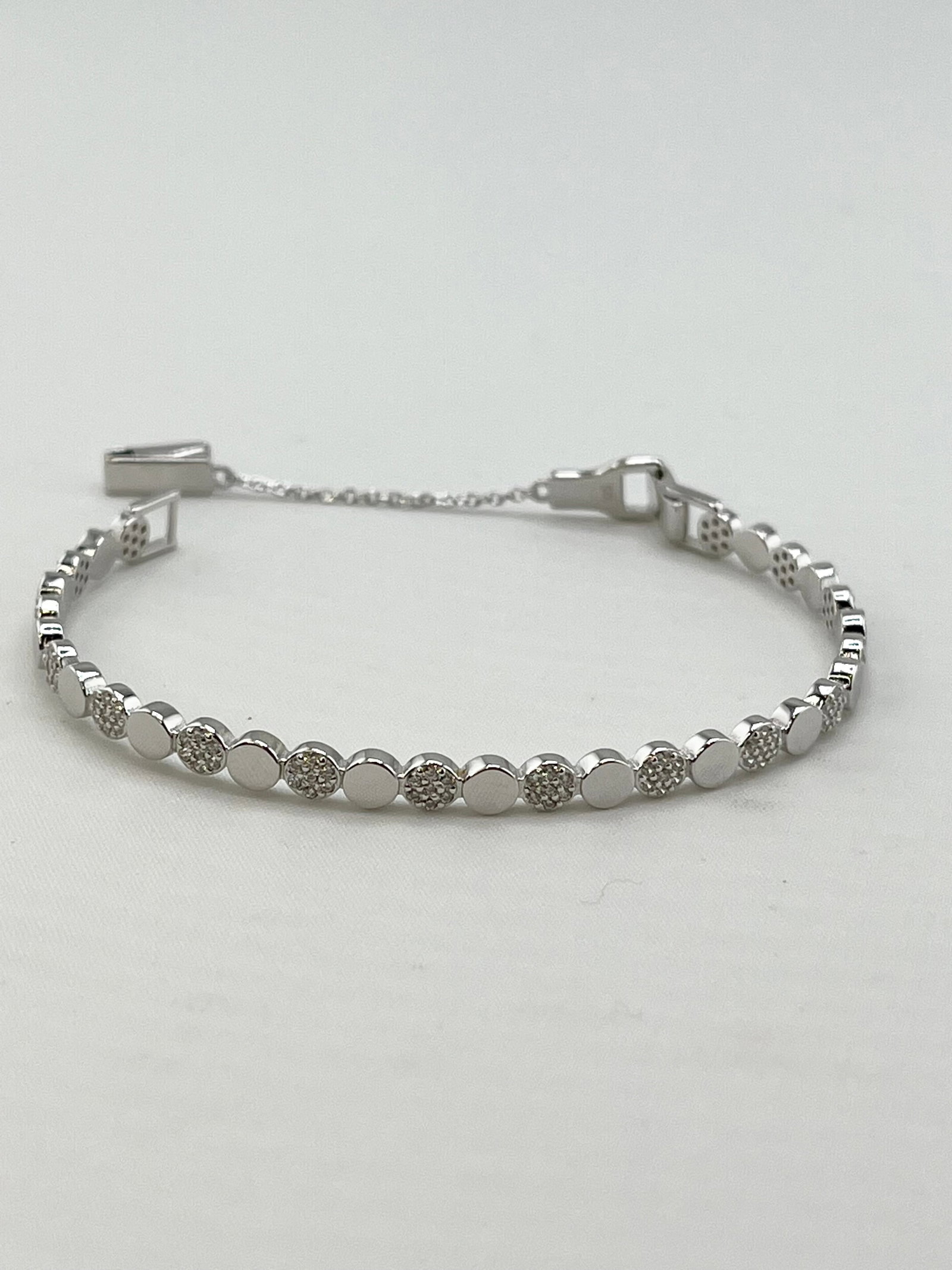 925 Sterling Silver alternating Round Disk Tennis Bracelet: 925 Sterling Silver alternating Round Disk Crystal Pave Details Hard Bangle Type With Chain Closure. 8.3 grams. size M