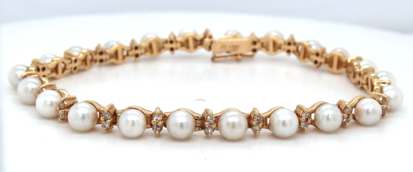 14kt Yellow gold pearl and diamond link bracelet: 14kt Yellow gold white fresh water pearl and diamond link 7-inch bracelet. The total weight of the bracelet is 14.2 grams.