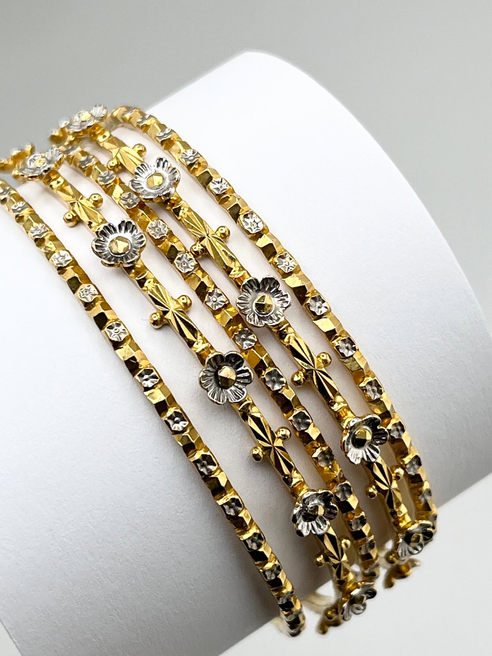 22KT Solid Yellow Gold Hand Made Set Of Five White Gold Flowe Design And Diamond Cut Finish Bangles: 22KT Solid Yellow Gold Hand-Made Set Of Five Bangles With White Flower Design And Diamond Cut Finish. 62.3 Grams , Size M