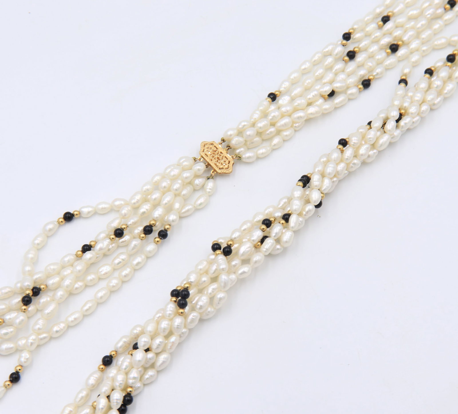 Black Onyx and Gold Ball Twisted Long Pearl Necklace: Black Onyx and Gold Ball Twisted 30 inches? Fresh Water Pearl Necklace with 14kt Yellow Gold Clasp. Total weight of Necklace 131.29 Grams.