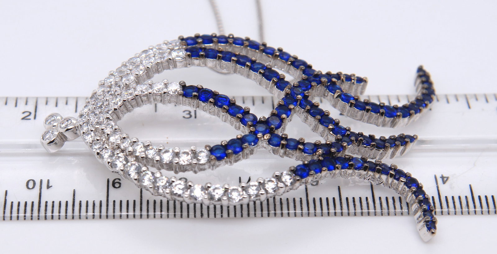 Sterling Silver Blue and Clear Cubic Zirconia Pendant on Chain: 925 Sterling Silver Blue and Clear Cubic Zirconia Pendant on 28 inches Box Chain Necklace. Total weight of Necklace 19.50 Grams.