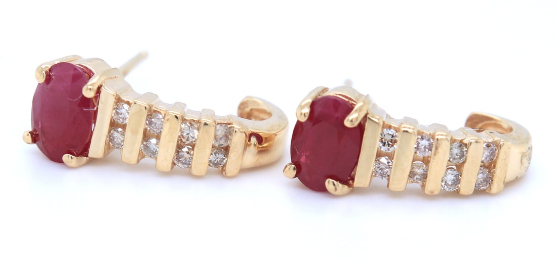 14kt Yellow gold oval ruby and diamond accent earrings: 14kt Yellow gold oval ruby and diamond accent earrings. Total weight of earrings 2.50 grams.