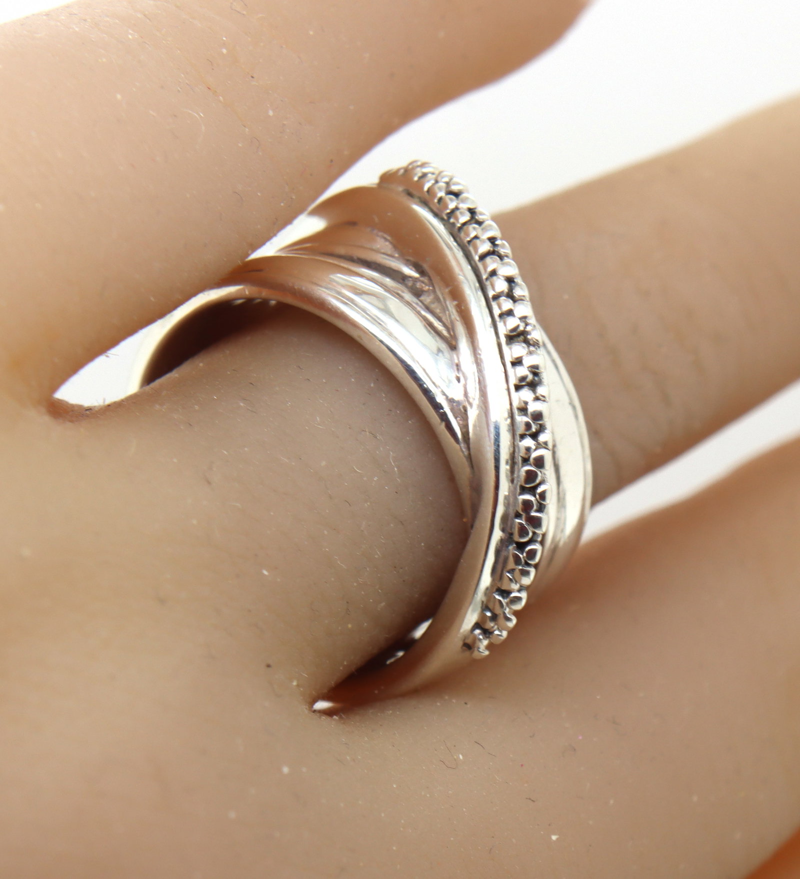 Michael Dawkins bead cross over ring in 925 sterling silver: Michael Dawkins bead cross over ring in 925 sterling silver. The total weight of the ring is 10.40 grams. Ring size 7.5".