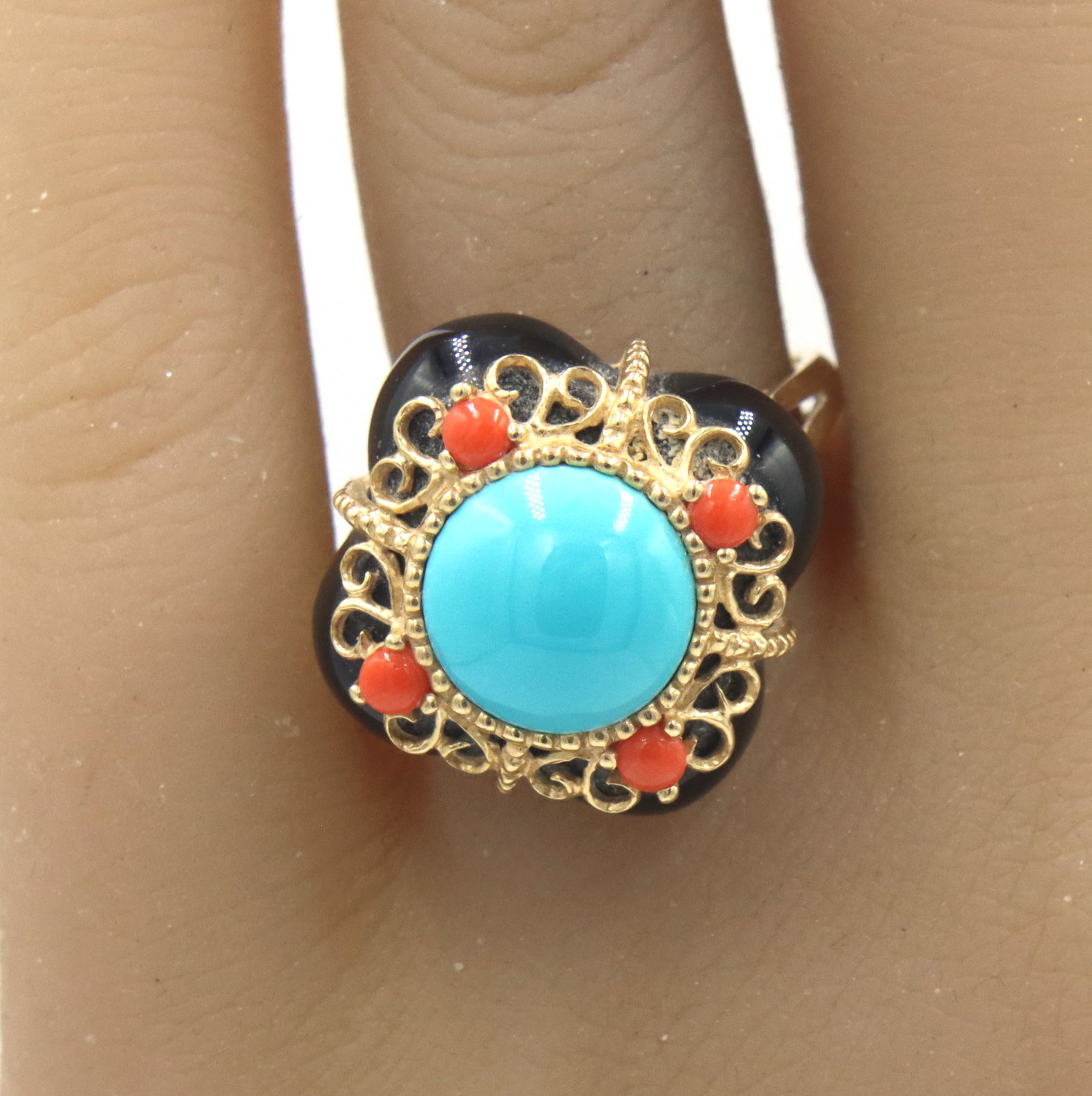 14kt Yellow gold black onyx, Turquoise and coral cocktail ring: 14kt Yellow gold black onyx, Turquoise and coral cocktail ring. The total weight of the ring is 7.4 grams. Ring size 10.25".