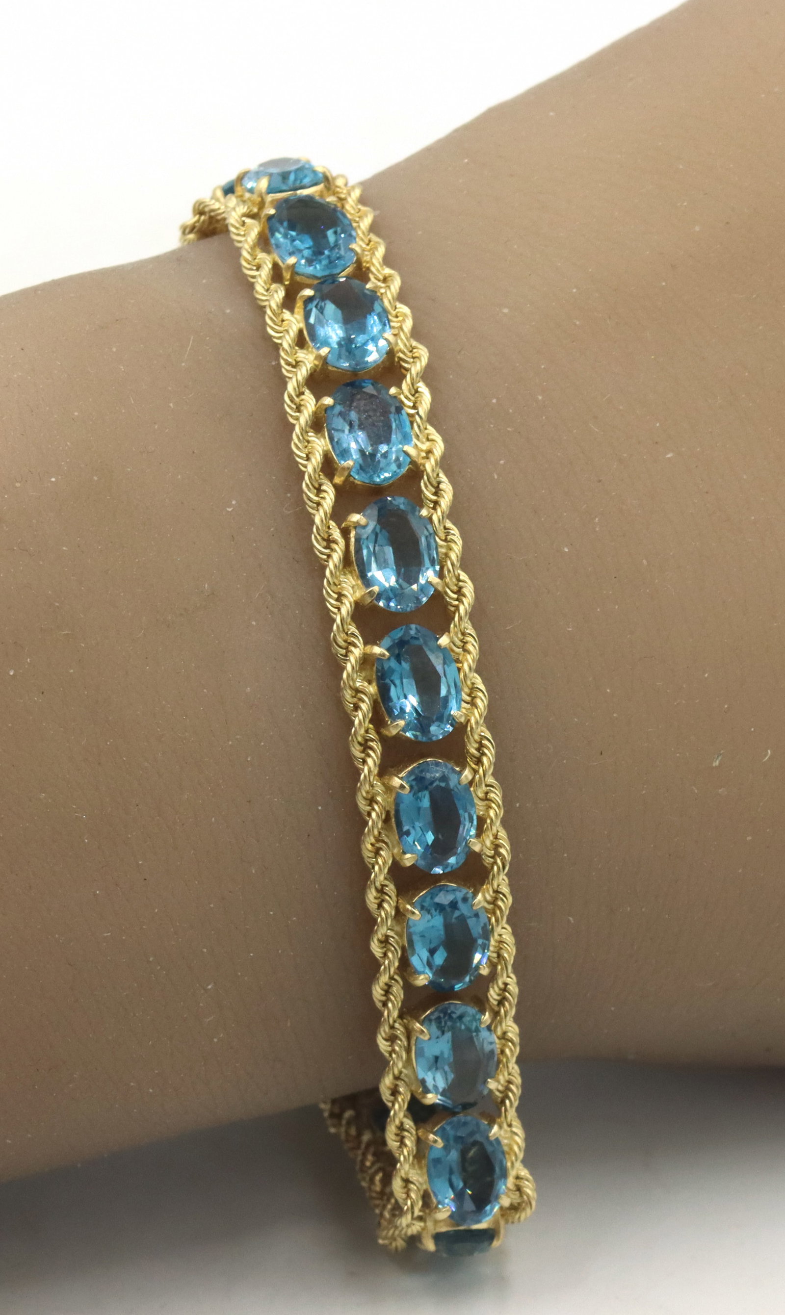 14kt Yellow gold blue topaz link rope bracelet: 14kt Yellow gold oval blue topaz link rope 7-inch bracelet. The total weight of the 15.4 grams.