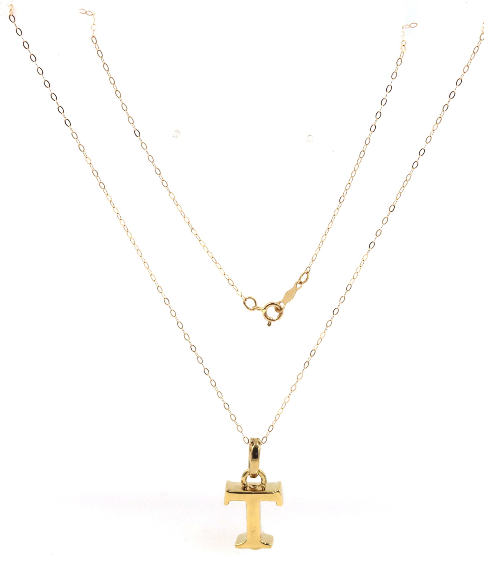 14kt Yellow gold T Charm pendant on chain: 14kt Yellow gold T Charm pendant on 18-inch chain necklace with spring ring clasp. The total weight of the necklace is 1.60 grams. Stamped: 14KT. This necklace is in excellent condition with no visibl