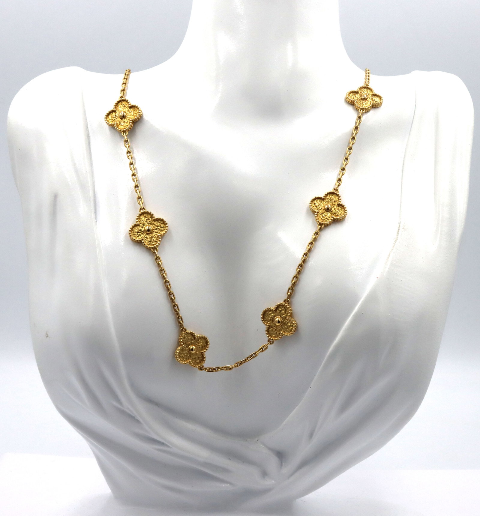 18kt Yellow gold 10 clover motif necklace: 18kt Yellow gold 10 clover motif 18-inch necklace with lobster clasp. The total weight of the necklace is 29.5 grams. (Designer inspired, not designer)