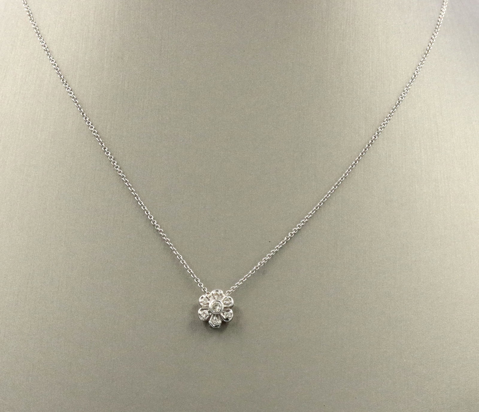 14kt White gold diamond flower style pendant on chain: 14kt White gold diamond flower style pendant on 16-inch chain necklace. The total weight of the necklace is 2.9 grams.