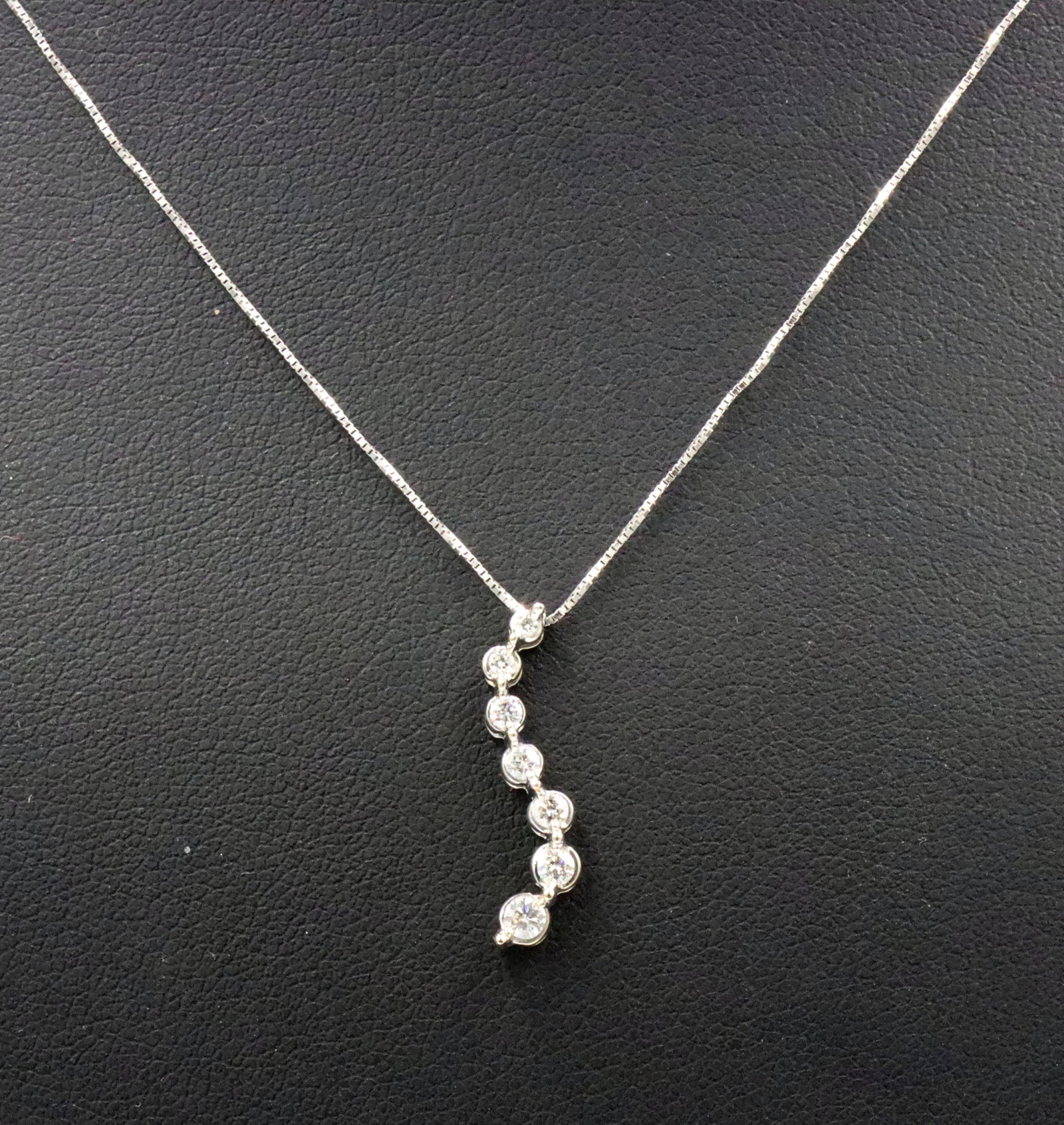 14kt White gold 0.15ctw diamond journey pendant on chain: 14kt White gold approximate 0.15ctw diamond journey pendant on 18-inch box chain necklace with spring ring clasp. The total weight of the necklace is 1.70 grams.