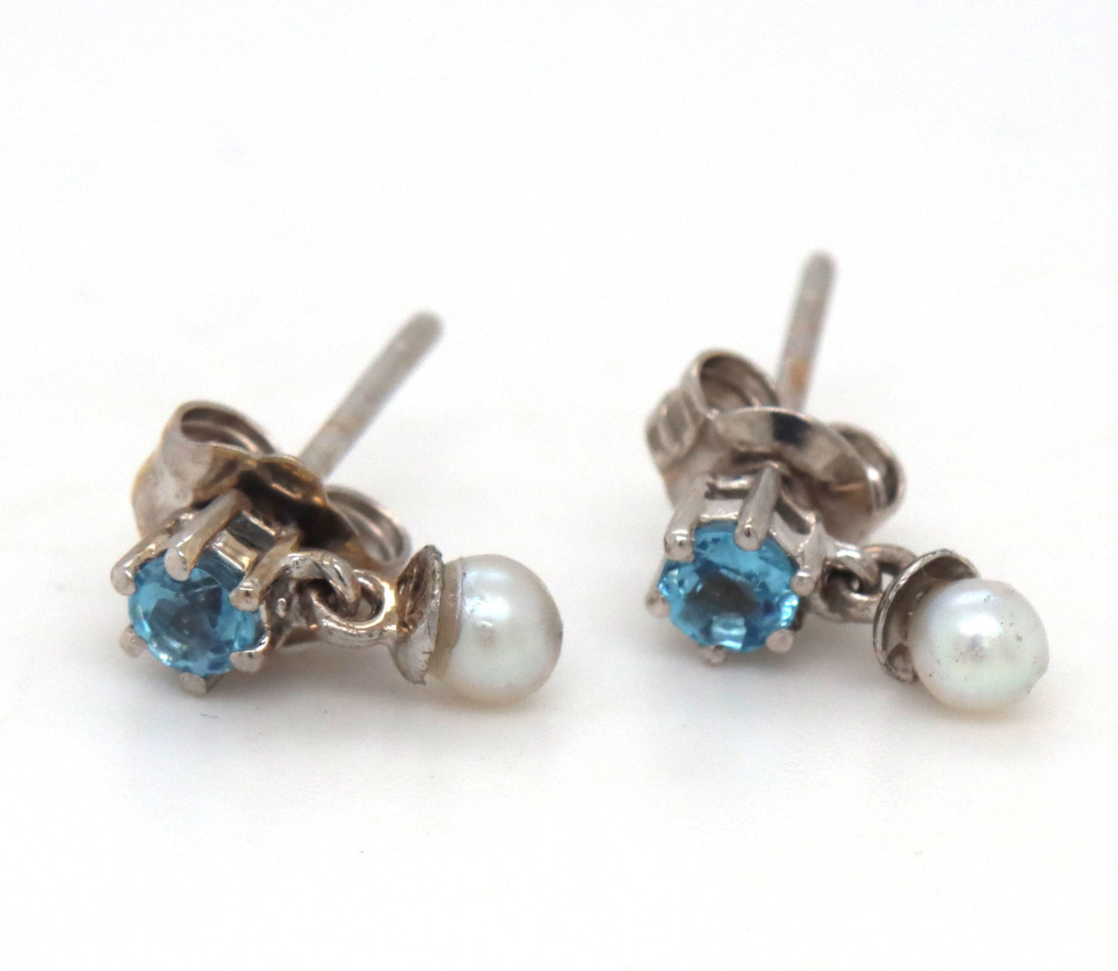 14kt White gold Pearl and blue topaz dangle earrings: 14kt White gold Pearl and blue topaz dangle earrings. The total weight of the earrings is 1.30 grams.