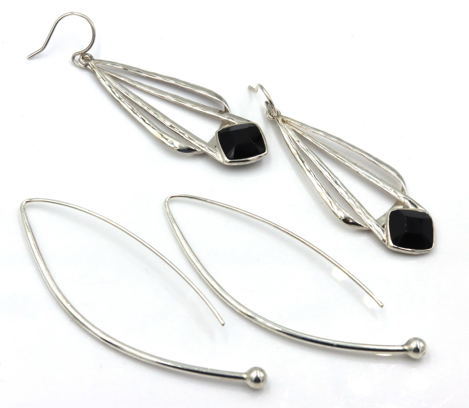 2 Pairs of 925 sterling silver dangle earrings: 2 Pairs of 925 sterling silver dangle earrings. The total weight of the lot is 14.60 grams.