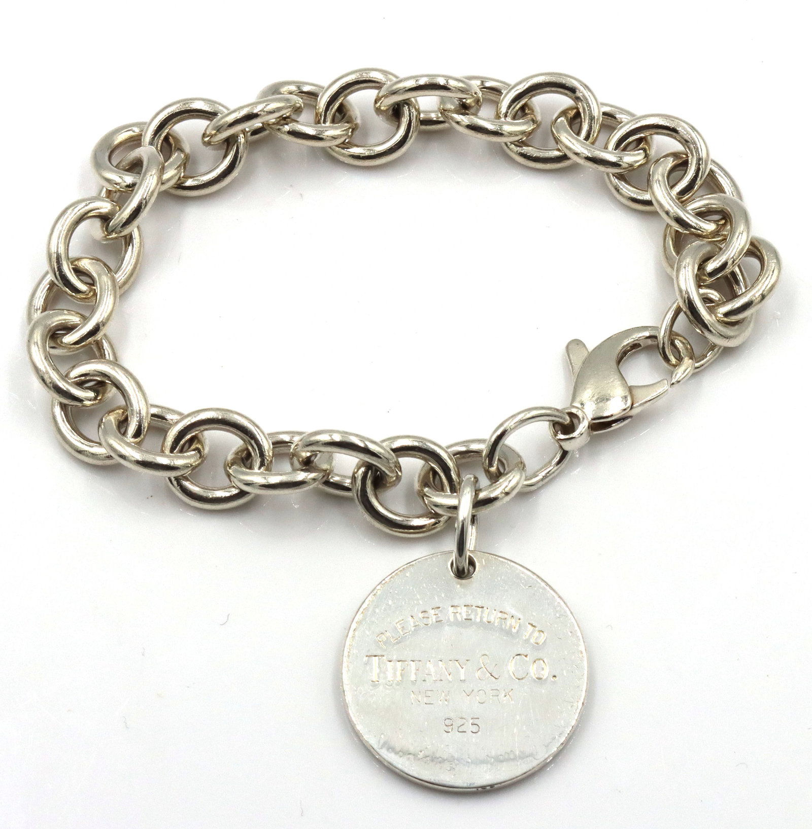 925 Sterling silver Tiffany & Co round tag charm bracelet: 925 Sterling silver Tiffany & Co round tag charm 7-inch bracelet. The total weight of the bracelet is 37 grams.