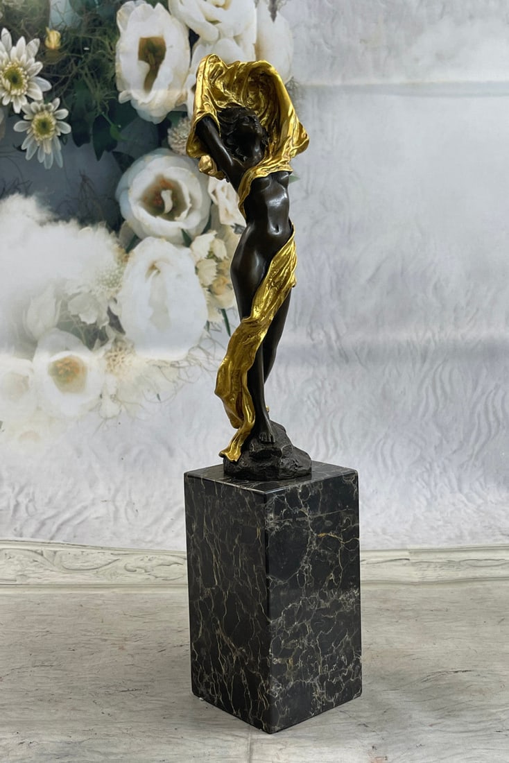 Sexy Topless Bronze Female Sculpture: This statue is a conceptual representation of a nude girl standing upright with a cloth loosely wrapped around her. She stares straight ahead with a look of intense concentration. Her hands are covere