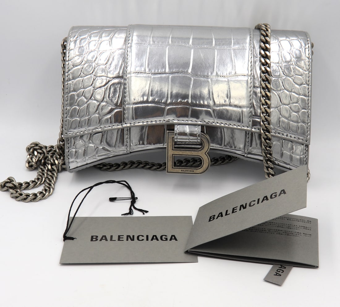 Balenciaga Hourglass Wallet on Chain Handbag: Authentic Preowned Balenciaga Hourglass Wallet on Chain Handbag. 7.5LX4.7HX1.9"W. Curvilibear Shape. Studded Magnet Closure. 6 Inner Card Slots. Made in Italy.