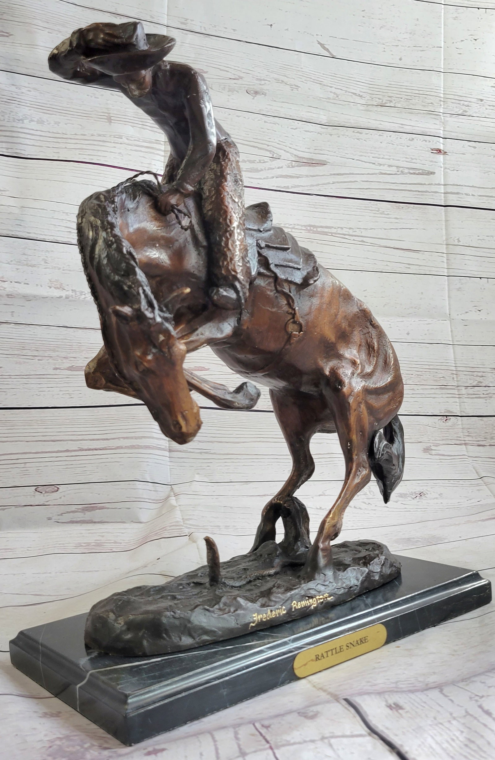 Cowboy Western Rattle and Snake Bronze Statue: This Bucking Bronco has quite fright once he sees a deadly rattlesnake slithering underneath him. In a panic, he starts to rear up and stomp the rattlesnake. The rider looks like the rider from Wooly