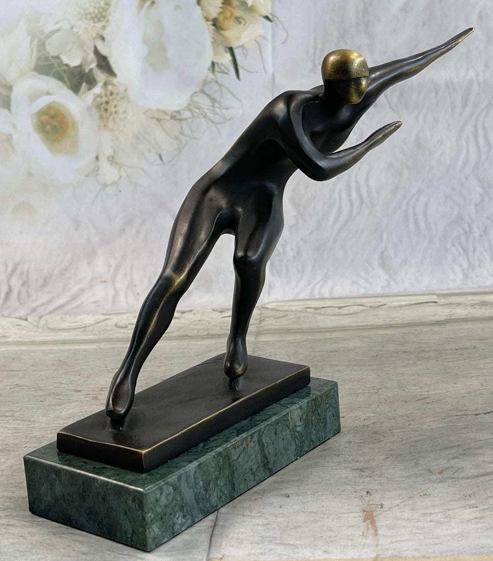 Ice Skater Bronze Sculpture on Marble Base Figurine: An Ice Skater puts on a show. Well trained in the art that she loves, she shows off her agility, balance, and flexibility. She elevates her long lean leg far behind her. Her chest pushes out and her h
