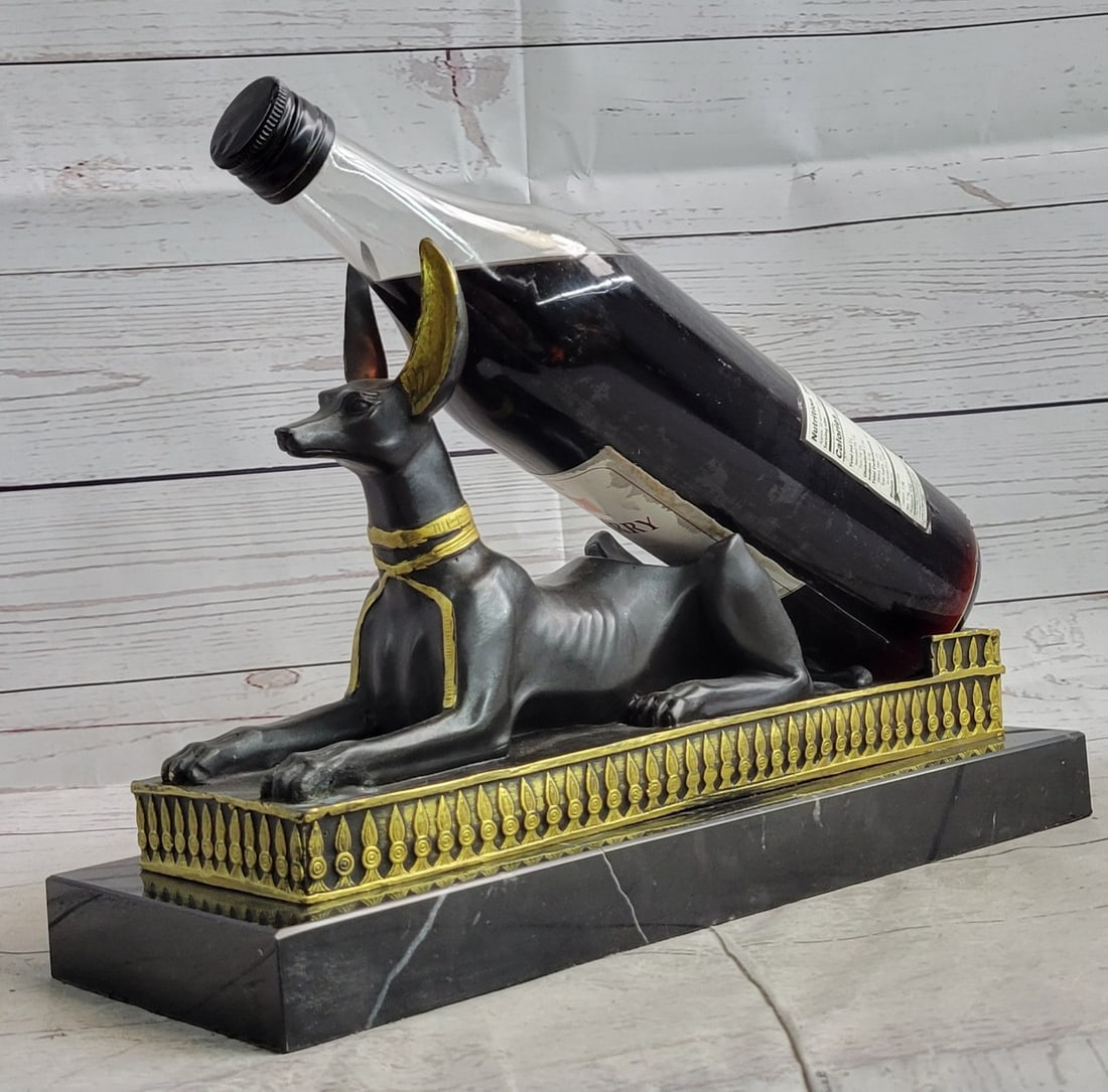 Win Holder Egyptian Anubis Jackal Bronze Sculpture: This gorgeous Egyptian Bronze Anubis has fine detail and gold accent patina. This bronze sculpture was crafted using the lost wax methods and mounted atop a marble base. Dimensions: Height 9 X Width