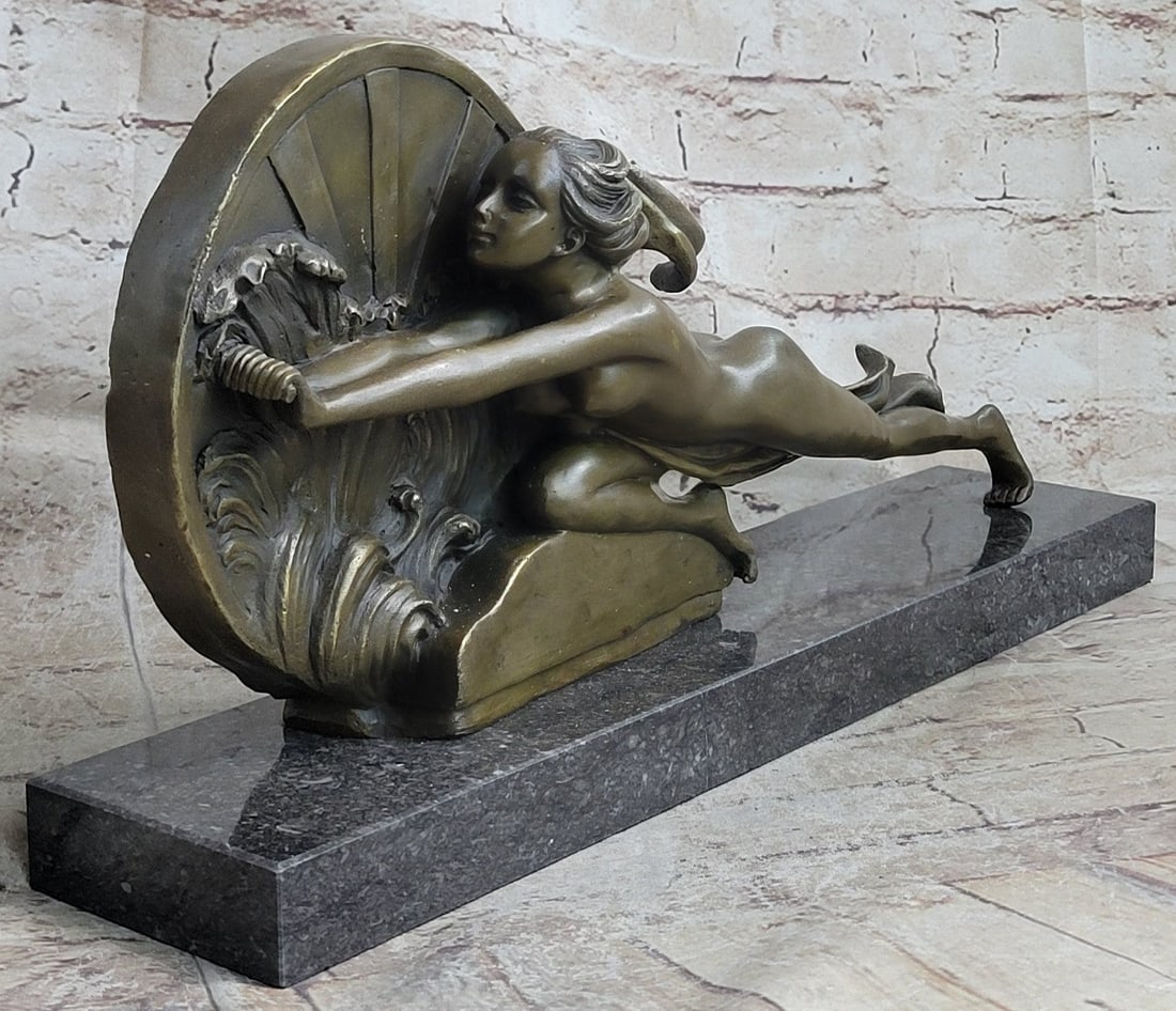 Nude Girl Bronze Sculpture: With grace, agility, and flexibility, this serene beauty is filled with the strength of ten men. Though her long lean body fiercely pushes a wheel, her face shows no strain or anguish. Quite the