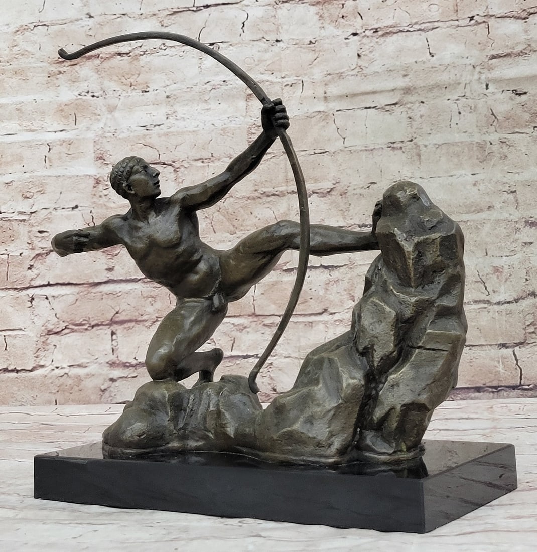 A Man With Bow Bronze Sculpture: A powerful archer leans back, bracing his muscular legs against a rock. He lines his arms and squints at his target. He releases and lets the arrow soar over the rocks. He clutches his tall bow,