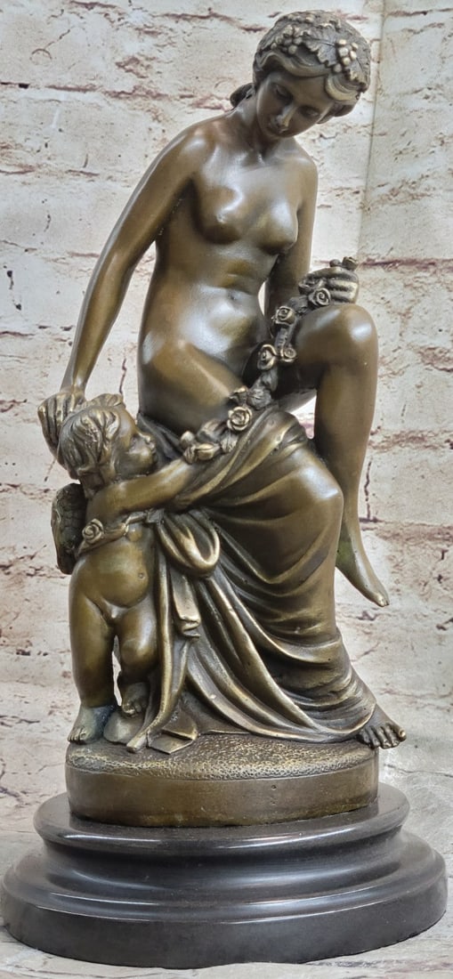 Young Cherub and a Lady Bronze Sculpture: A young cherub reaches to a woman to gain her attention. The beautiful woman reaches back to the cherub with a delicate to his playful curls. She is holding a row of rosebuds in this enchanting
