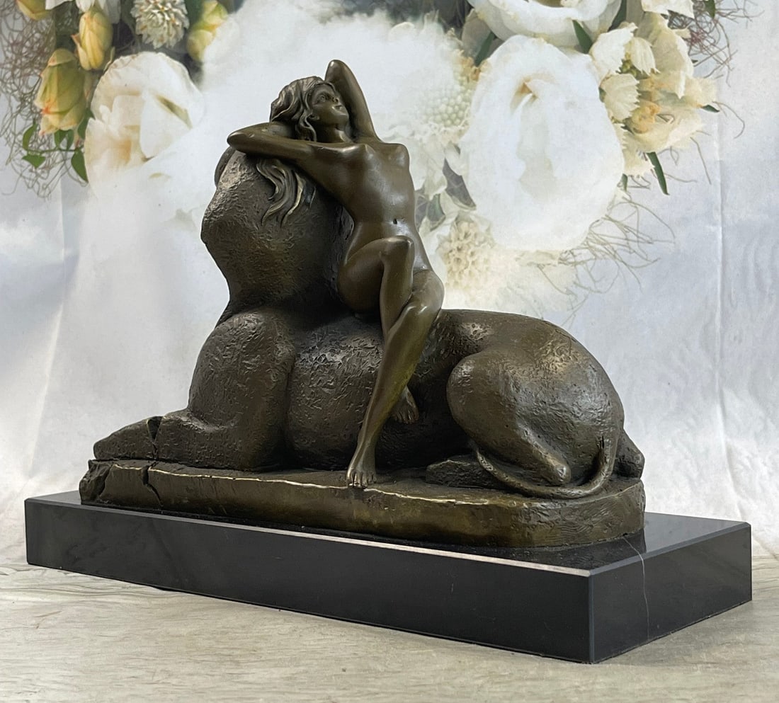 French Nude Nymph Resting on Sphinx Bronze Sculpture: This exceptional French Art Nouveau figure calls upon classical influences. This stunning work captures a languid beauty lounging against a noseless Sphinx, a nod to both the neoclassical tradition in