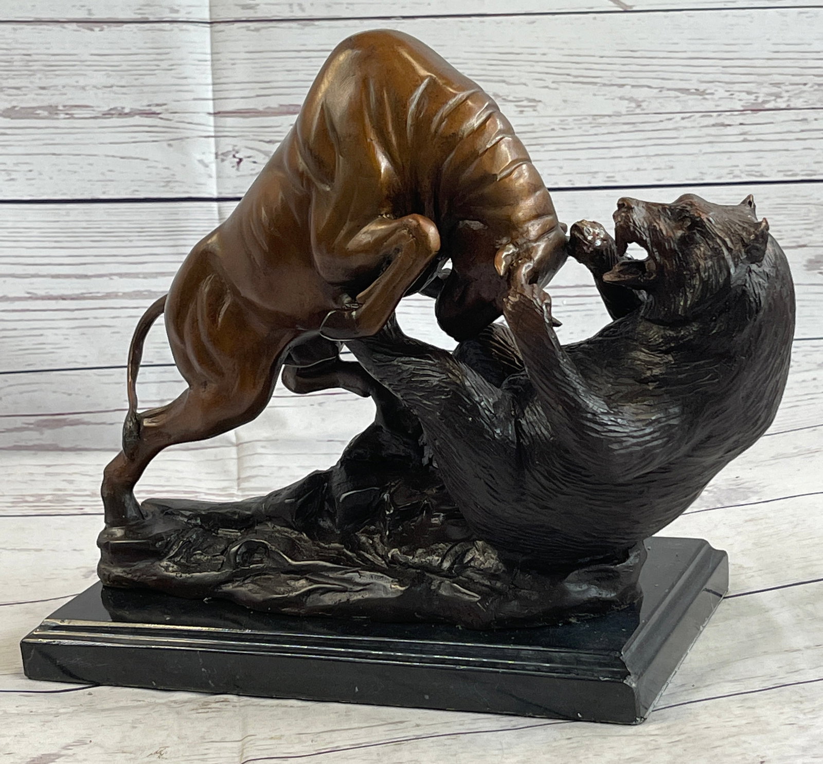 Animal Trophy Bull and Bear Bronze Sculpture: A fierce battle has broken out between two known killers. Bull vs. Grizzly bear. The bull charges its horns in and the bear locks his massive paws over its head, pulling him into his plump body. The b