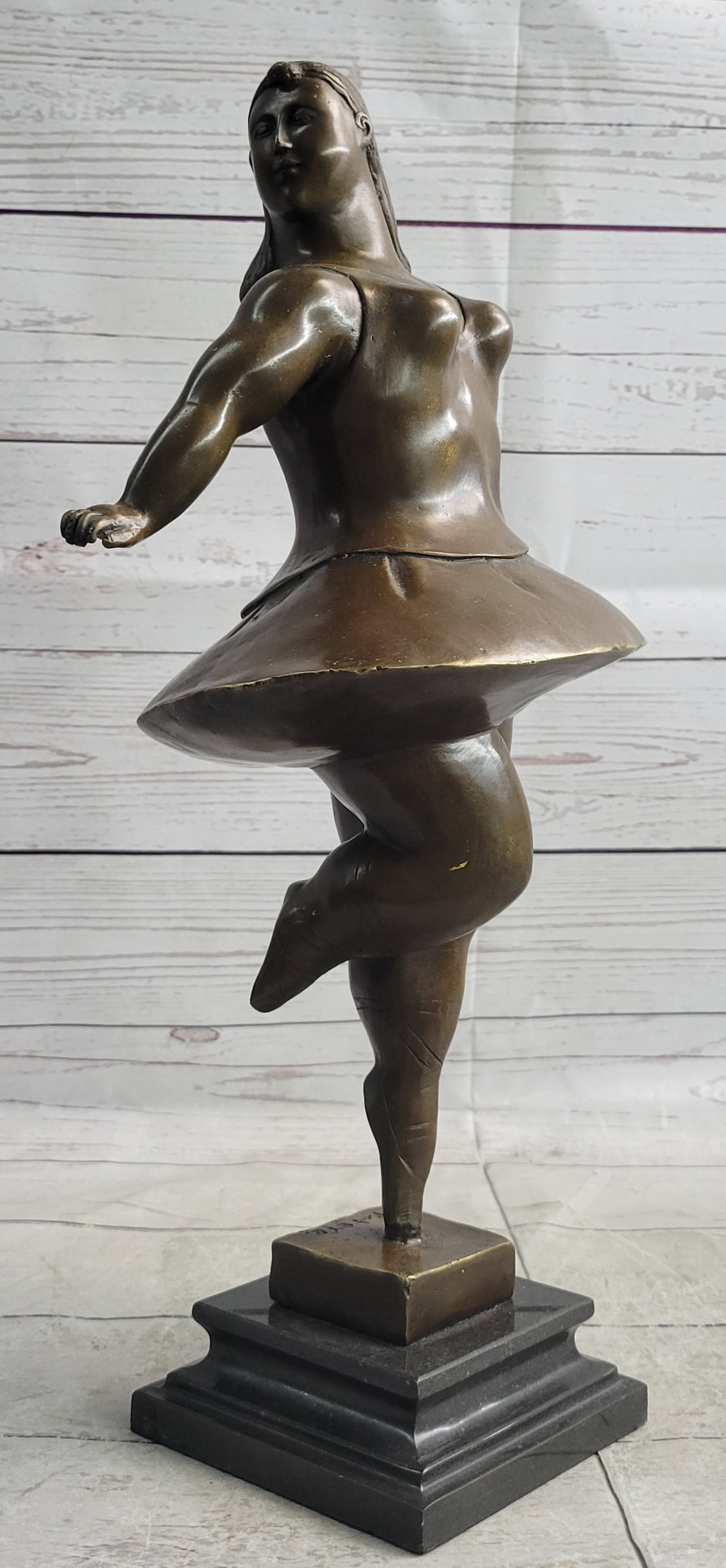 Ballerina Bronze Statue: The ballerina is representational of exaggeration of form. The beholder can be immediately drawn to the round and plump shape of the sculpture enough to want to run a hand over the surfaces. This is