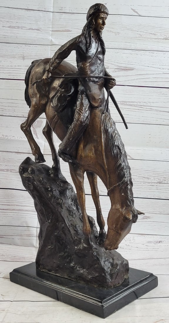 Mountain Man Bronze Sculpture: This Sculpture is titled Mountain Man. It is of a man and his horse ascending down steep mountain terrain. The mountain man himself carries a long rifle on his side and wears leather chaps, a shirt wi